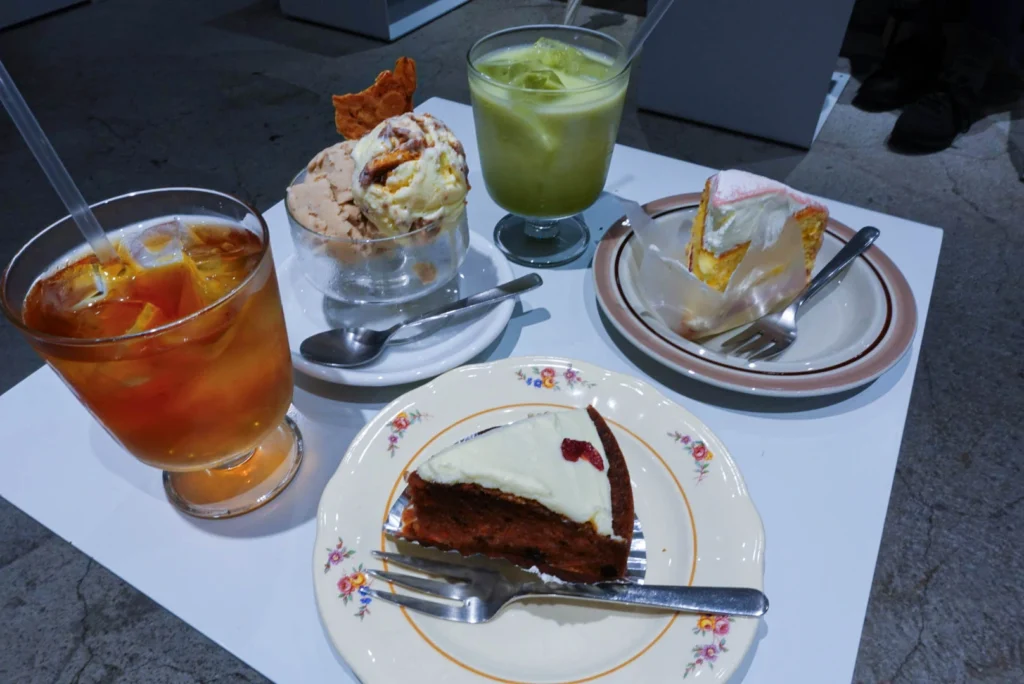 A selection of cakes, ice cream, and iced drinks on a table at Fika Fabriken cafe in Setagaya.