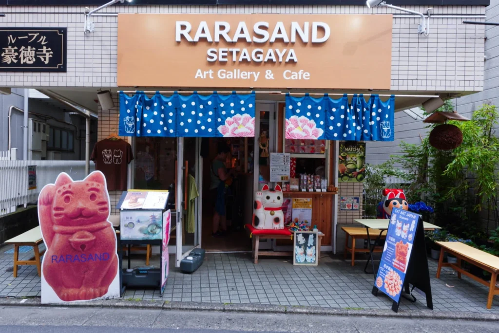 The storefront of Rarasand cafe in Setagaya, featuring a large sign for their Maneki-neko shaped baby castella treats.