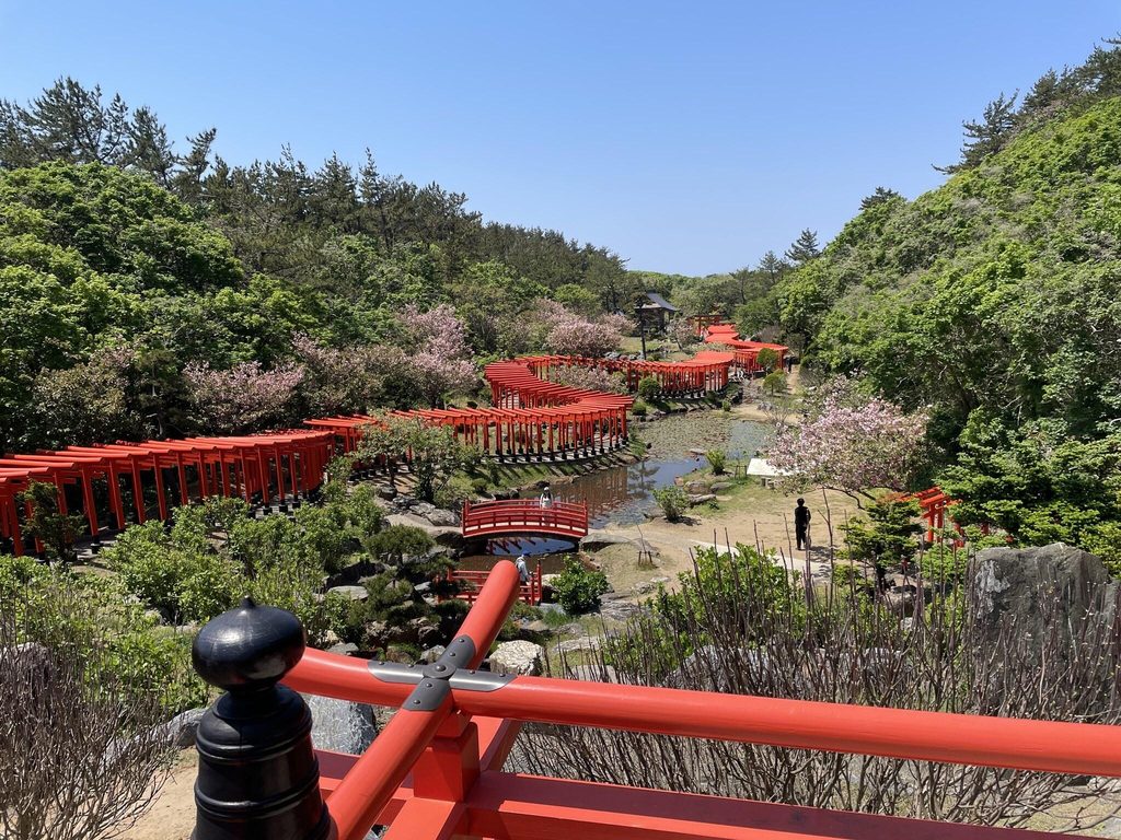 Serpentine rows of red torii gates winding through the garden at Takayama Inari Shrine Serpentine rows of red torii gates winding through the garden at Takayama Inari Shrine