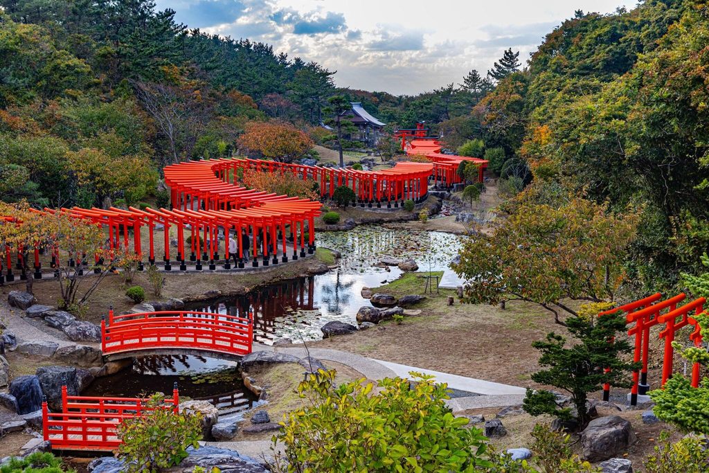 The torii loops and red bridge at Takayama Inari Shrine in autumn The torii loops and red bridge at Takayama Inari Shrine in autumn