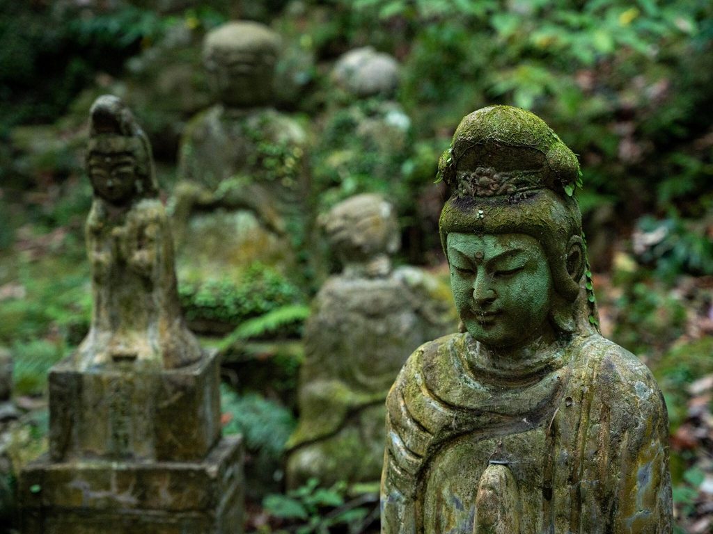 A moss covered stone arhat figure on the approach to Reigando A moss covered stone arhat figure on the approach to Reigando