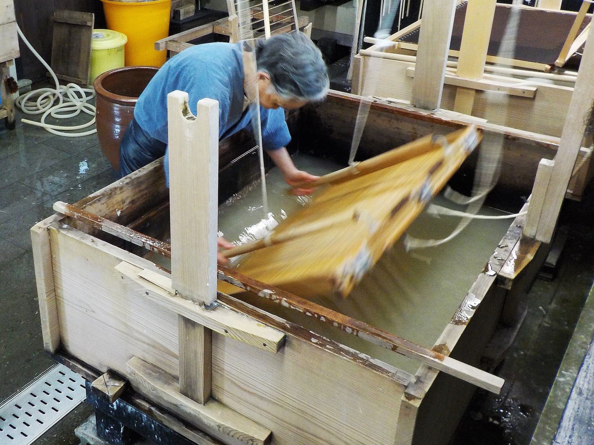 Traditional Japanese washi papermaking with a wooden screen