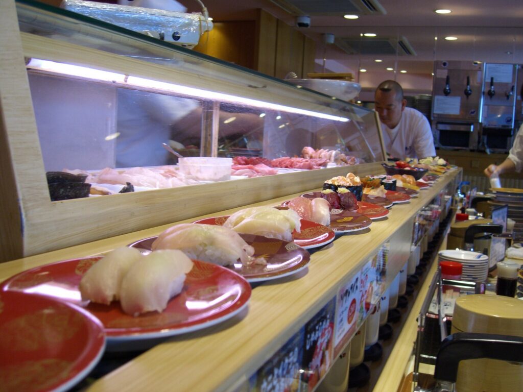 Plates of nigiri on a conveyor belt at a kaiten-zushi restaurant in Tokyo