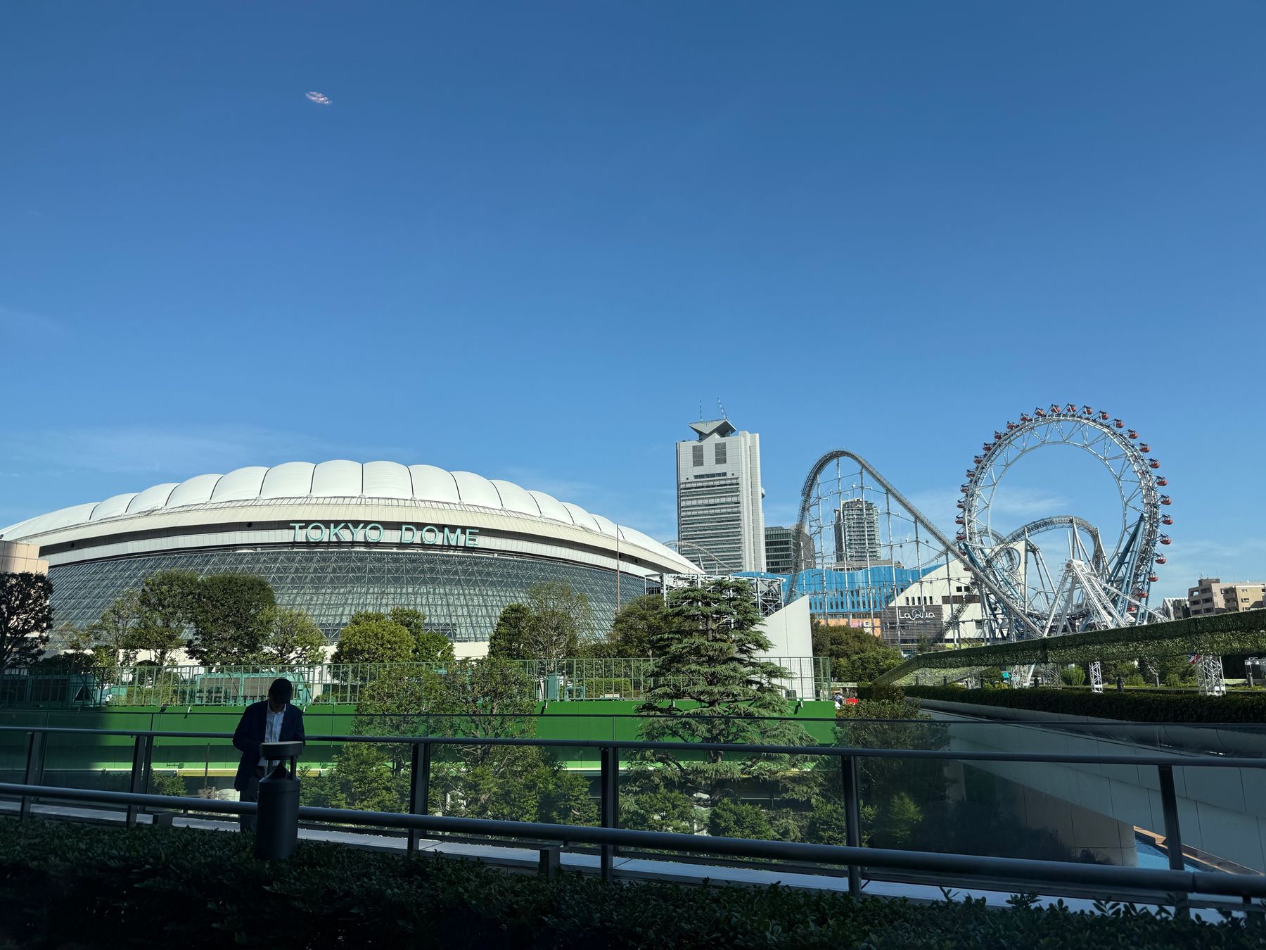 Tokyo Dome on a clear day with Tokyo Dome City rides behind it