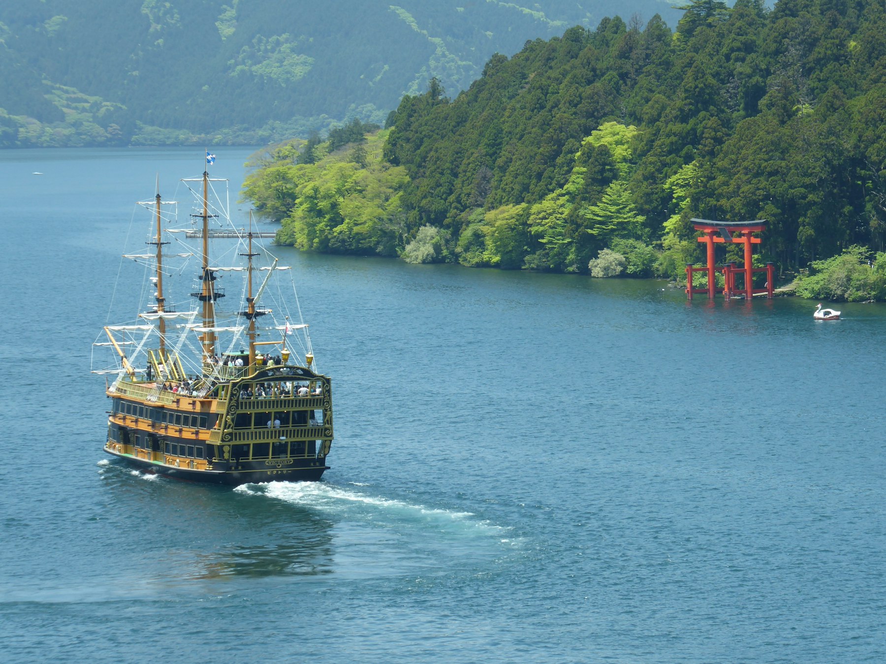 Hakone itinerary stop: a Lake Ashi sightseeing boat passing the red Hakone Shrine torii in the water