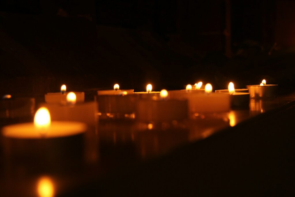 Lit candles glowing in a dark hall, the mood of the Great Hall at Studio Tour Tokyo at Christmas