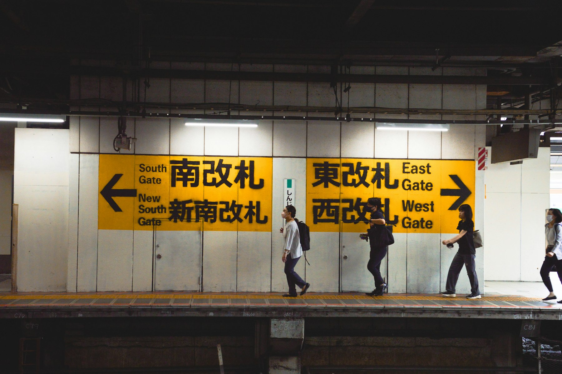 Signs pointing to the ticket gates in a Tokyo metro station