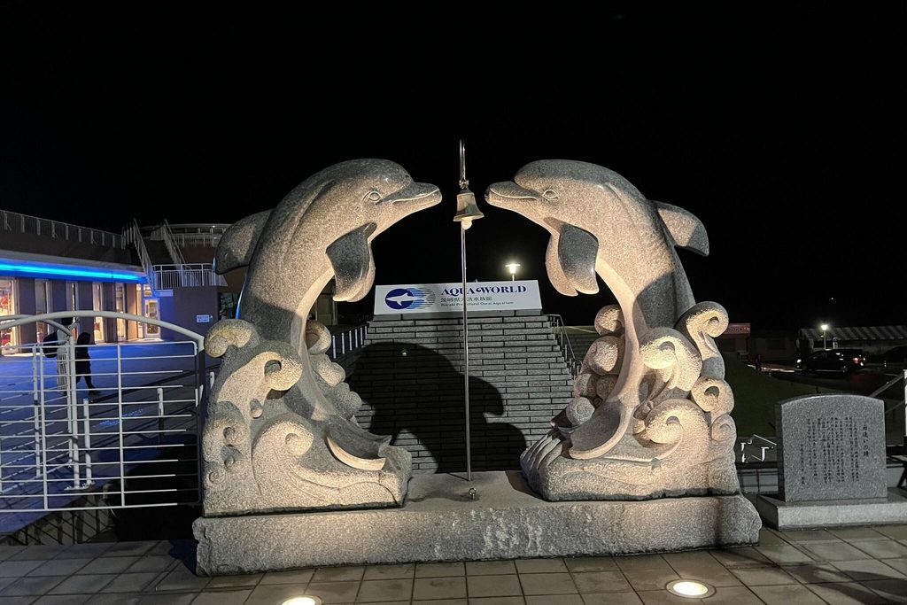 Dolphin statues lit up at night at the entrance to Aqua World Oarai Dolphin statues lit up at night at the entrance to Aqua World Oarai