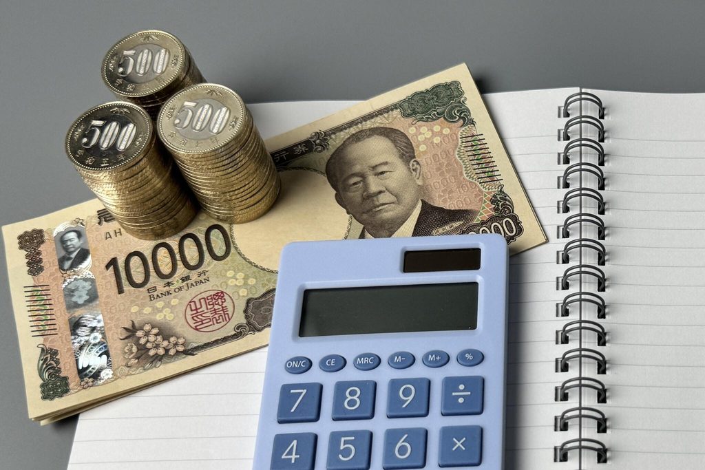 Yen notes, ¥500 coins and a calculator