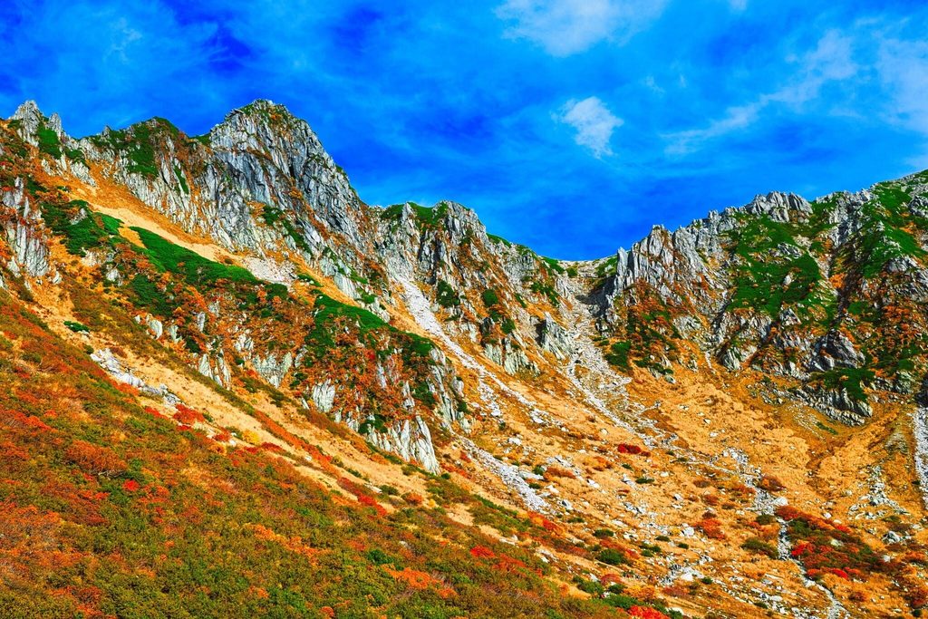 Fall foliage across Senjojiki Cirque, below the jagged ridge of the Central Alps Fall foliage across Senjojiki Cirque, below the jagged ridge of the Central Alps
