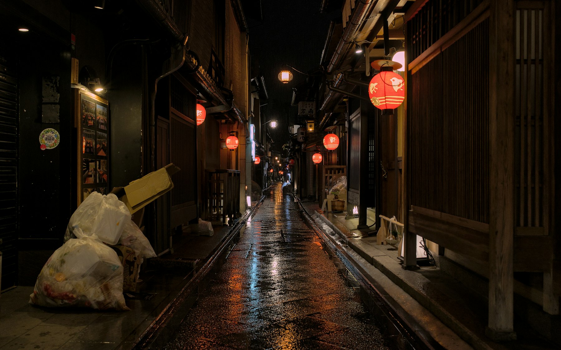 Narrow lantern-lit lane at night in Kyoto
