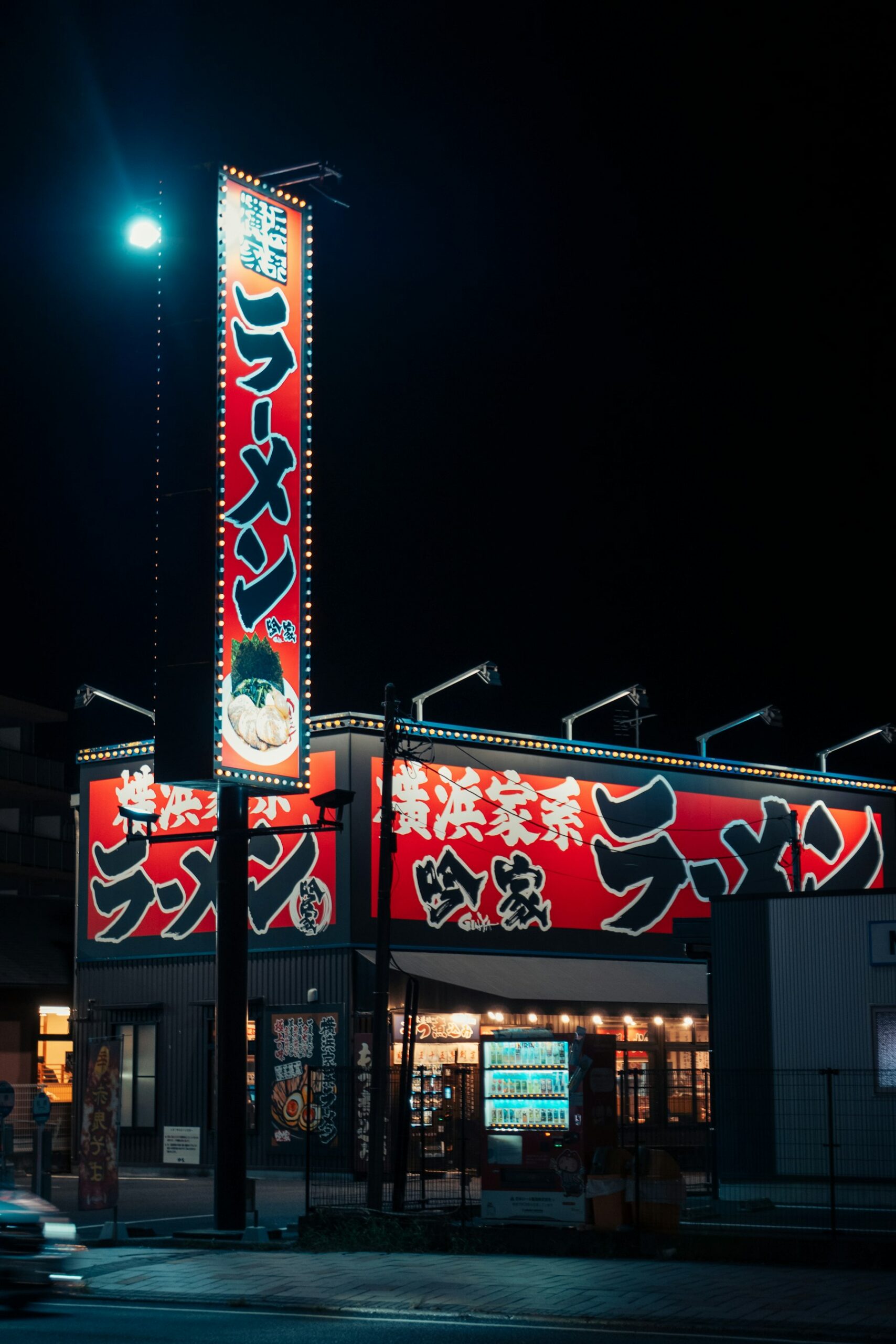 Ramen restaurant with bright red signs at night in Narita, Chiba
