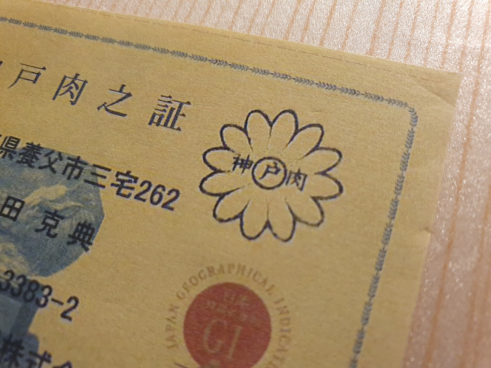 Kobe beef certificate (神戸肉之証) with the Nojigiku chrysanthemum stamp and GI mark, used to spot real Kobe beef