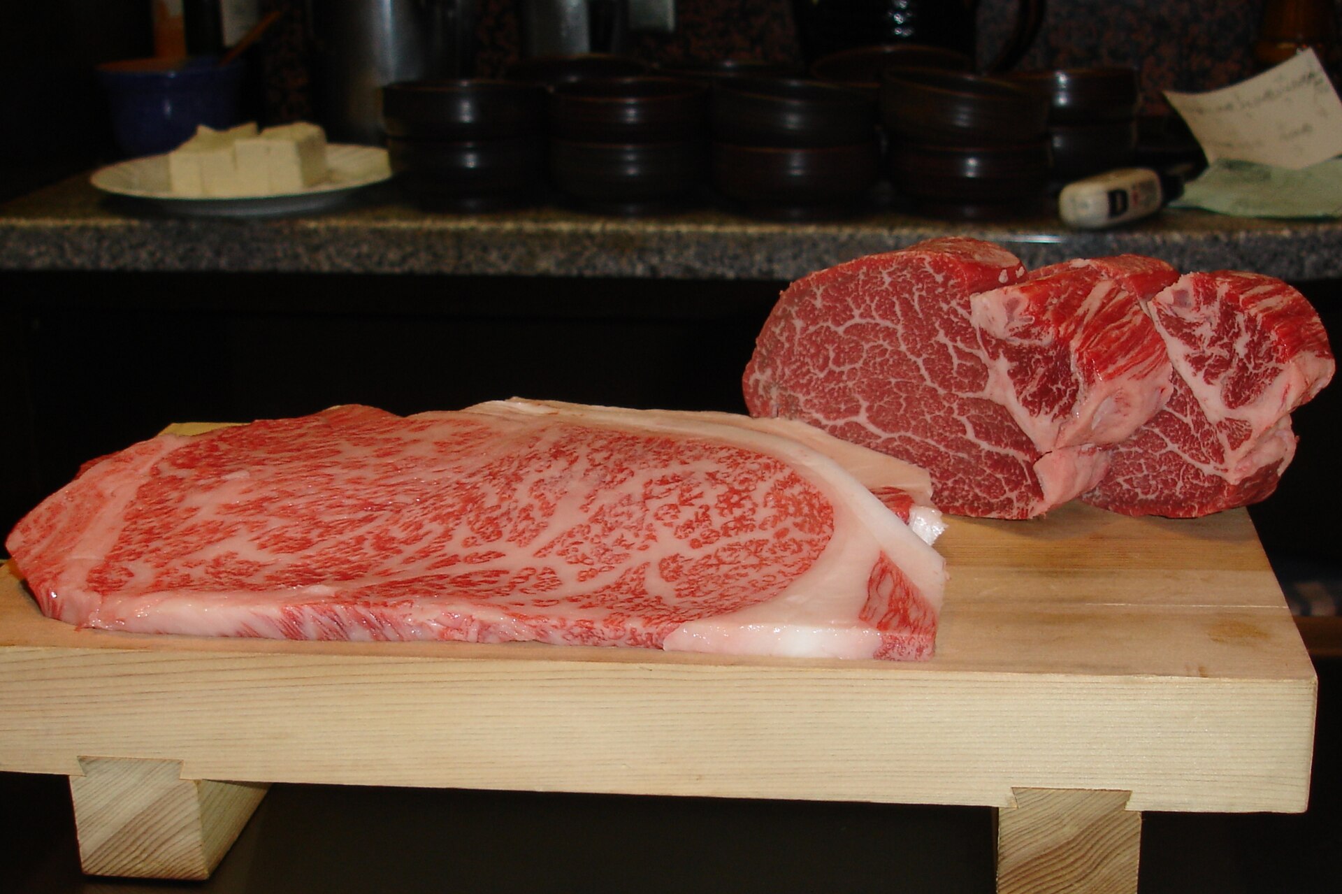 Kobe beef restaurants in Kobe: marbled Kobe beef steaks on a wooden board in Kobe, Japan