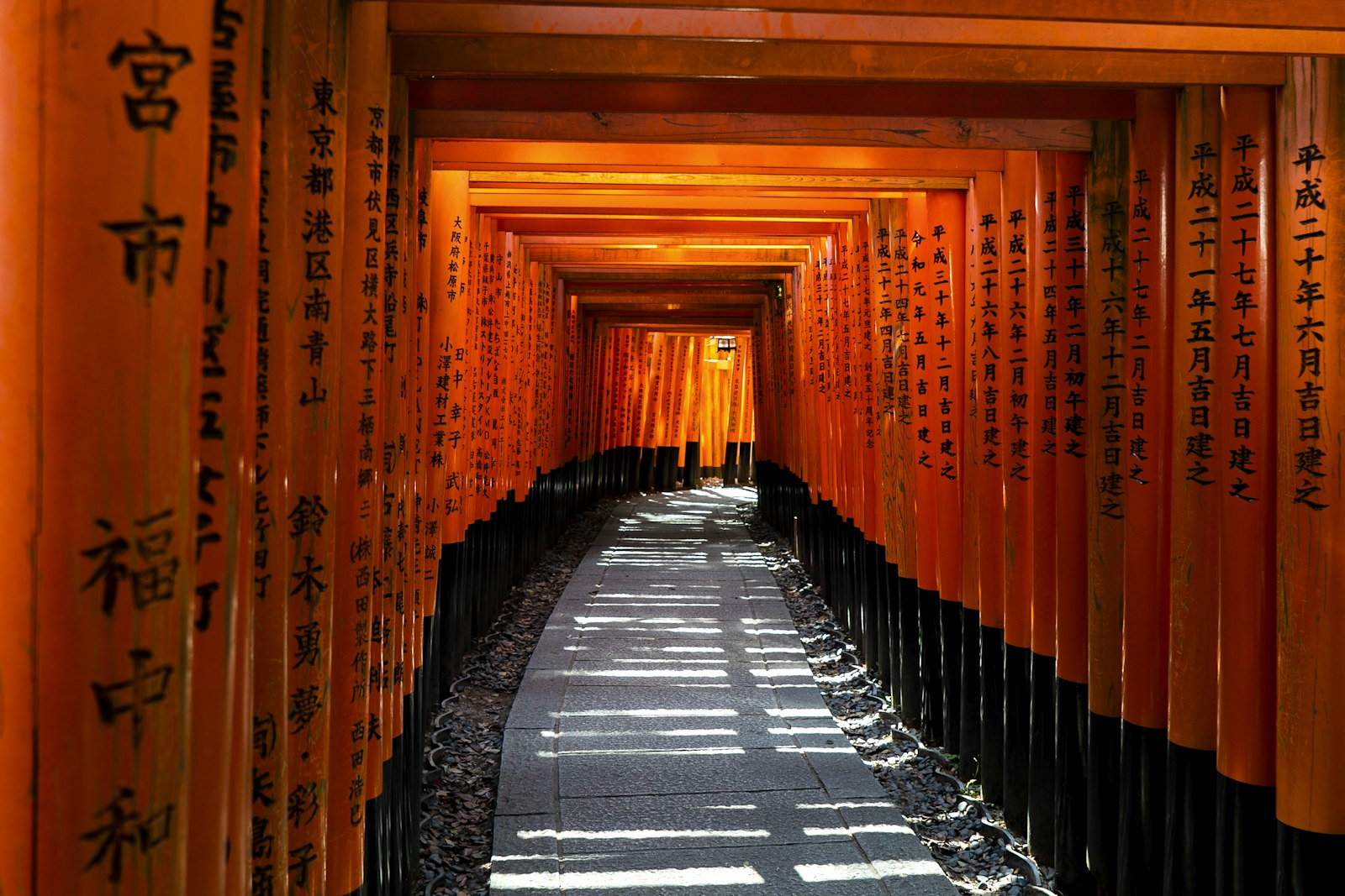 京都奈良一日遊:京都伏見稻荷大社橘紅色鳥居隧道中的石板路