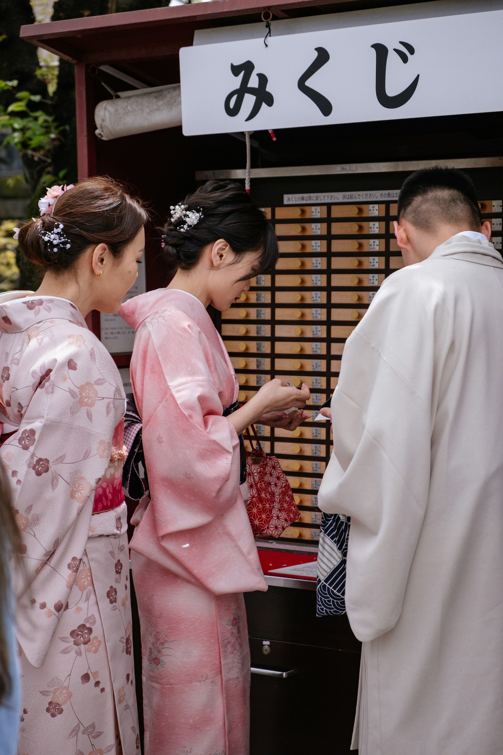 東京のお正月：神社でおみくじを引く着物姿の参拝客