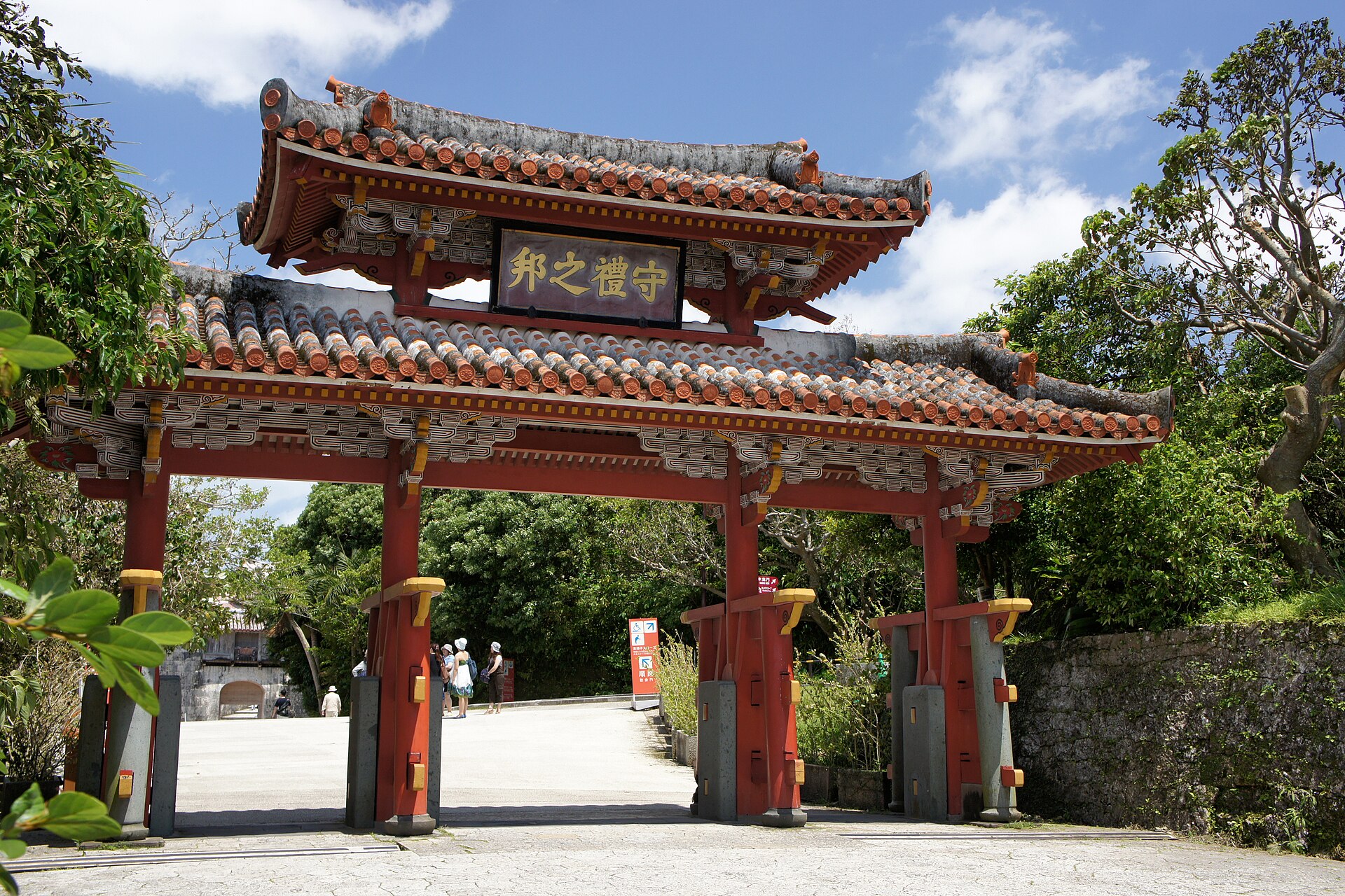 Shuri Castle reopening 2026: Shureimon gate at Shuri Castle in Naha, Okinawa, its red lacquered pillars and tiled roofs set against a blue sky