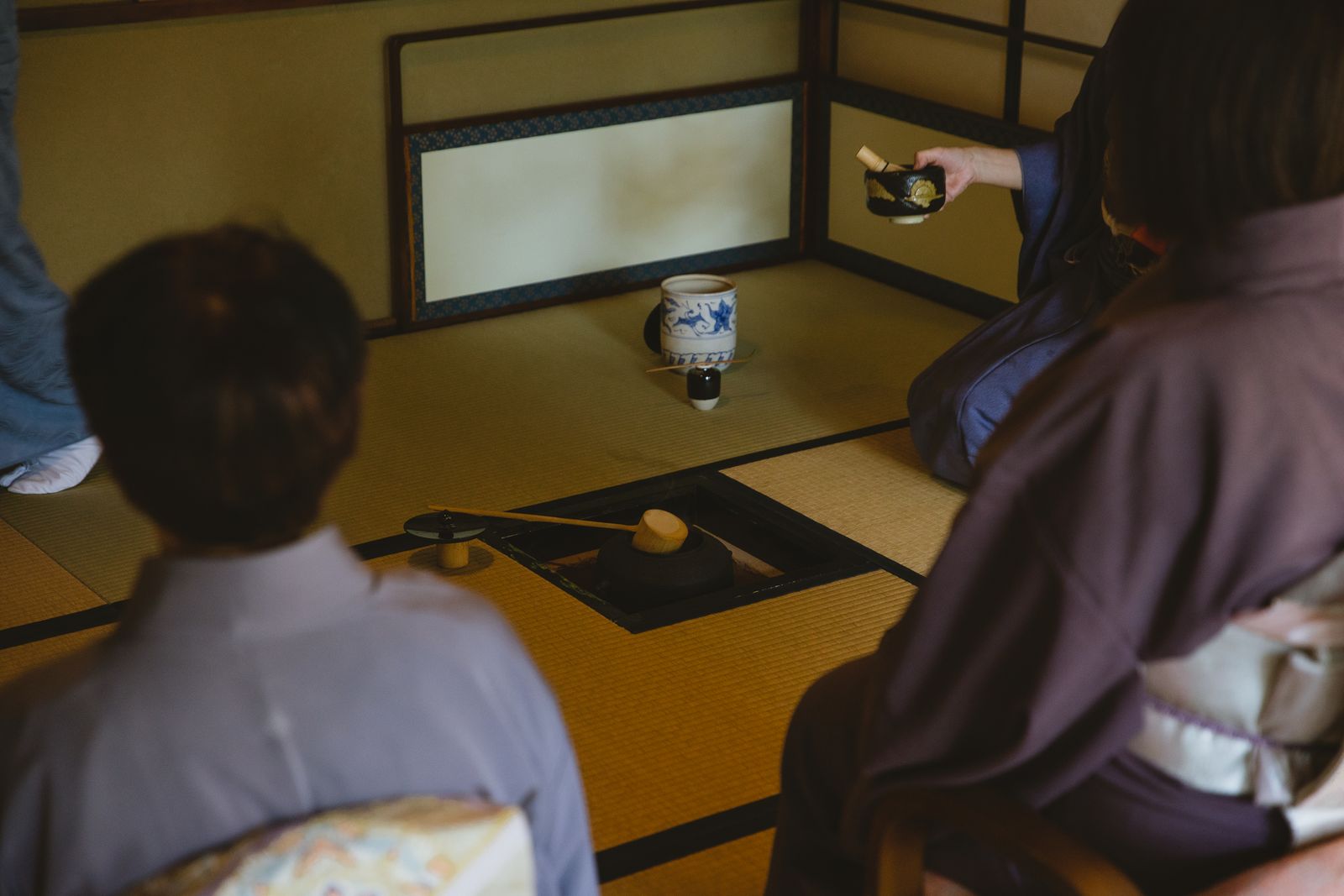 Tea ceremony utensils and guests on tatami in a tea room