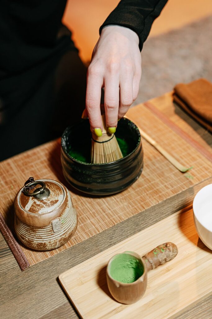 Tea ceremony Tokyo – hand whisking matcha with a bamboo chasen in a tea bowl