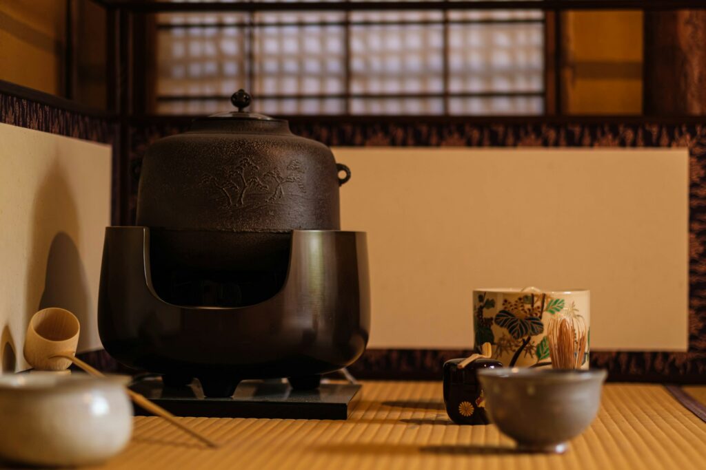 Japanese tea ceremony room setting with iron kettle and tea utensils on tatami