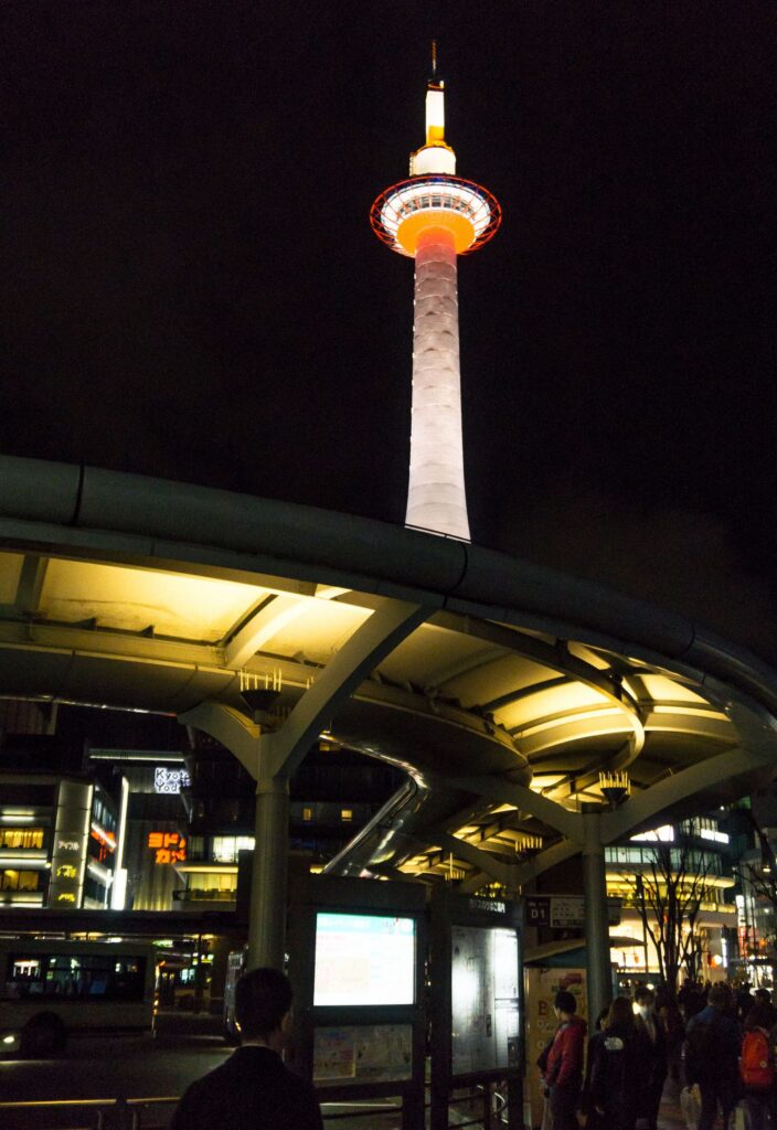 Kyoto Tower lit up at night near Kyoto Station, the gateway to teamLab Biovortex Kyoto