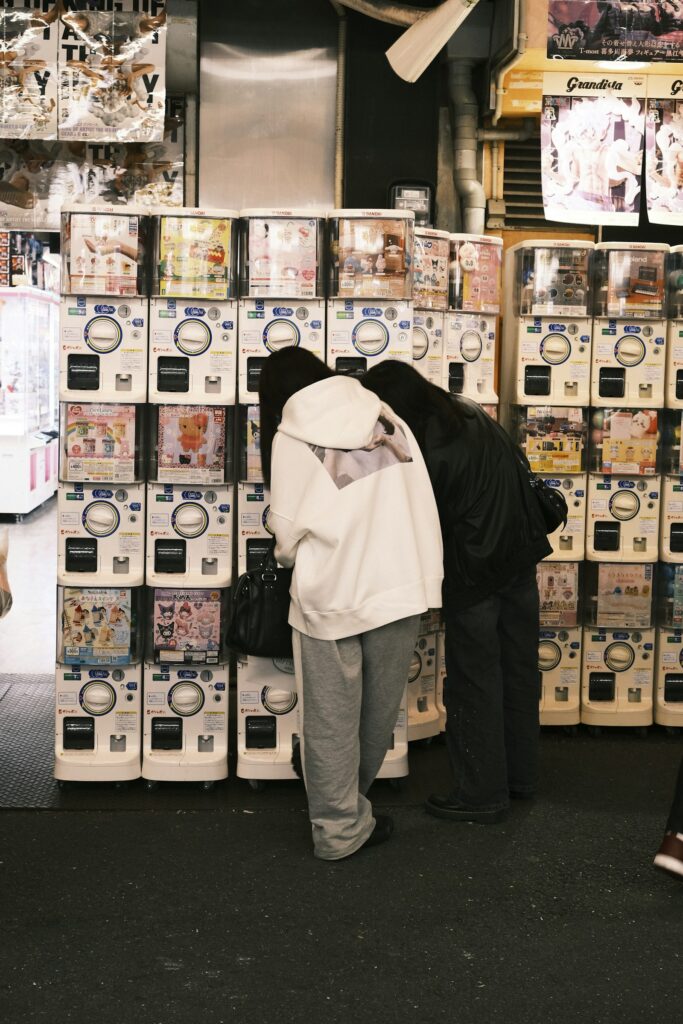 Akihabara gachapon: shoppers looking at capsule toy machines stacked high in Japan