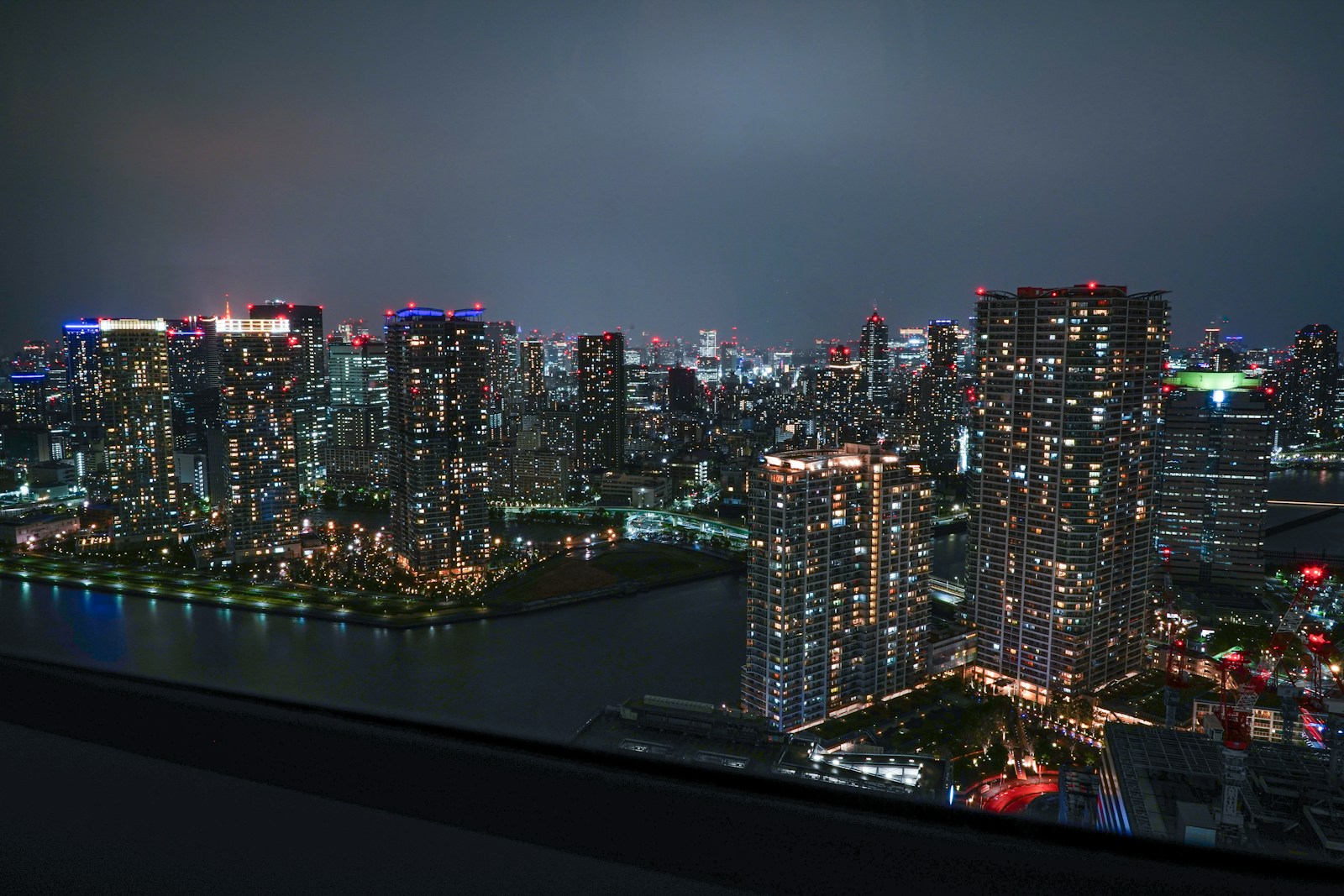 Tim Burton labyrinth Tokyo venue area: Toyosu waterfront towers at night over Tokyo Bay